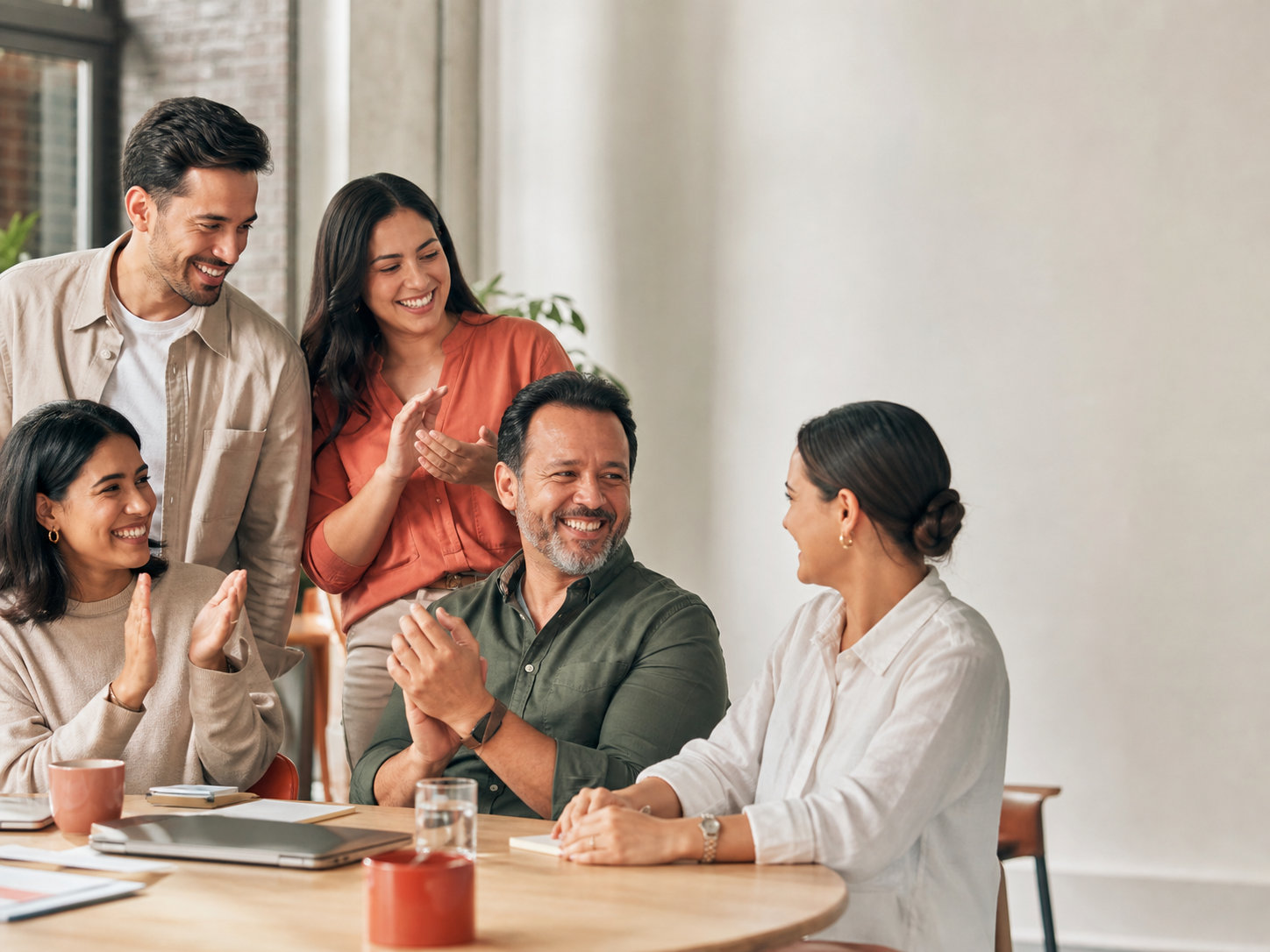 Equipo de trabajo compartiendo alrededor de una mesa
